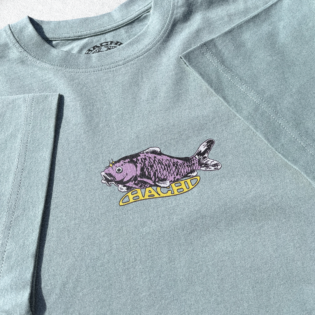 Close up of a Light green Hachiman JPN oversized organic t-shirt featuring a pastel colour front print of a huge Japanese koi carp sat above a wavy Hachi logo.