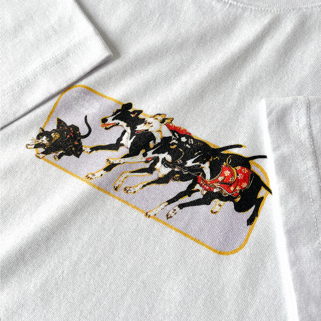 White relaxed organic t-shirt with a Japanese graphic of a cat wearing a kimono scurrying away from several greyhounds. Close up.