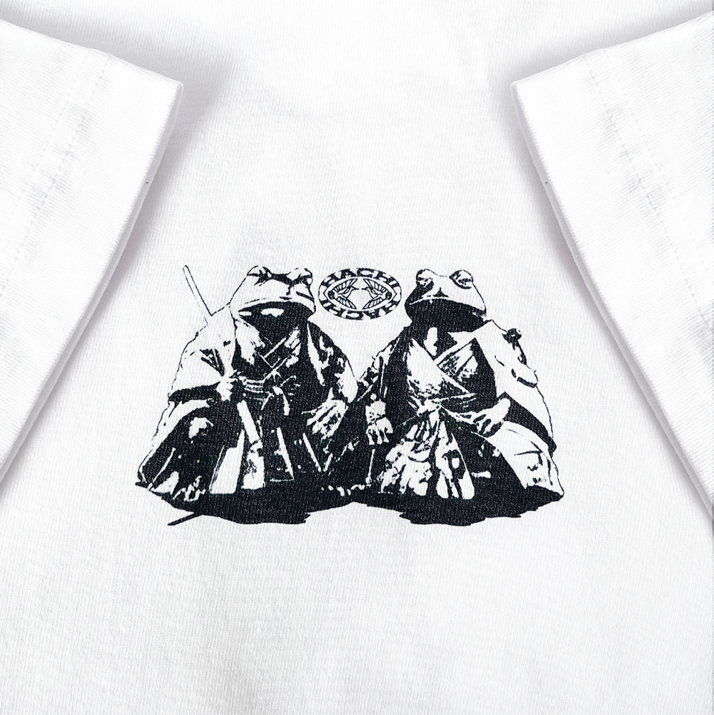 Close up of a Hachiman JPN white oversized organic t-shirt featuring a black front print of two frogs sat wearing traditional Japanese samurai attire.