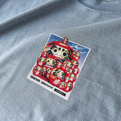 Stone Blue Heavy Oversized T-shirt with a Japanese graphic of daruma dolls on the front. Close up.