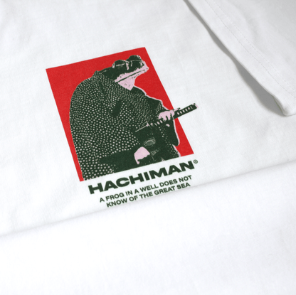 Close up of a Hachiman JPN white organic t-shirt featuring a red and green front print of a samurai frog wearing a kimono with a katana at his hip.
