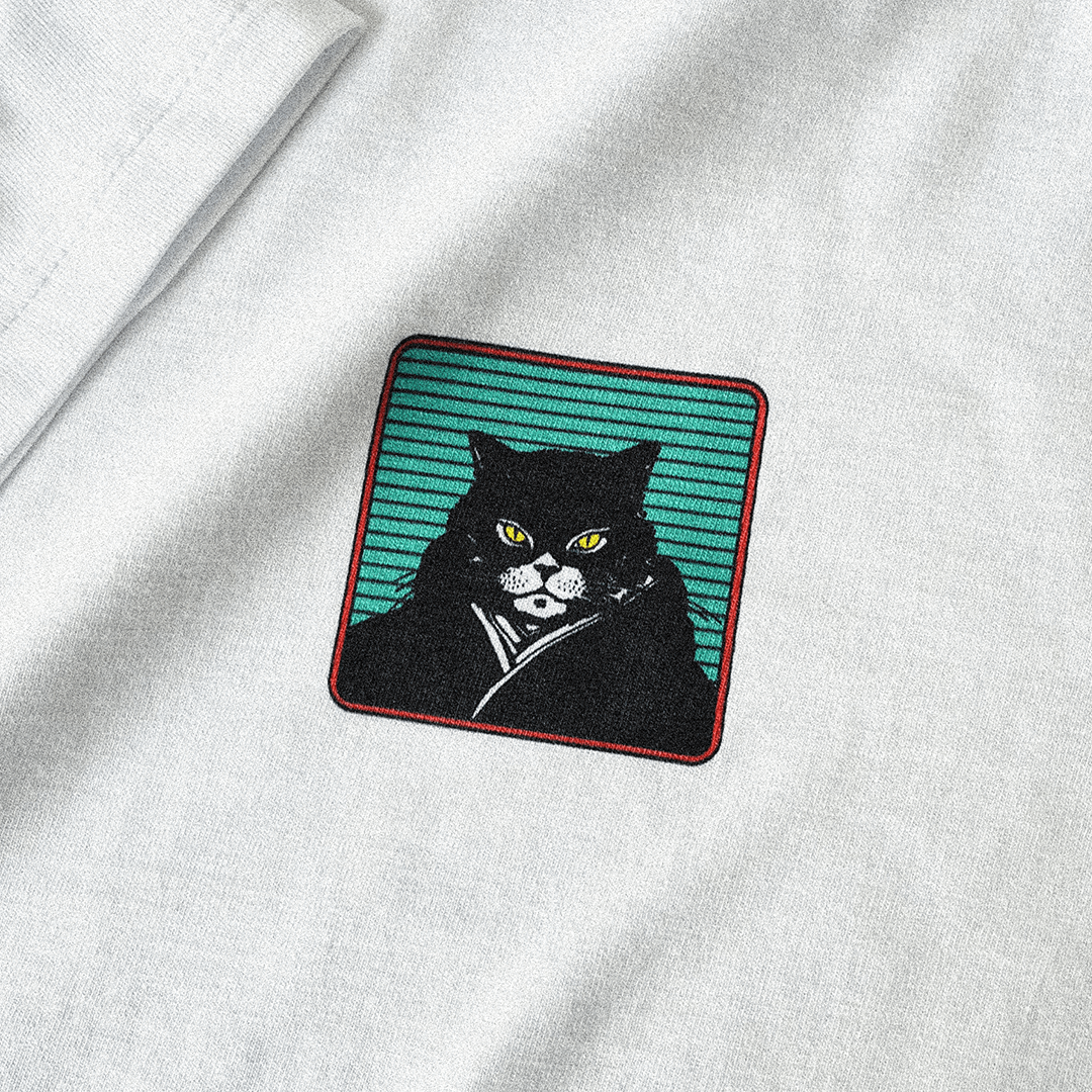 Close up of a Hachiman JPN white organic t-shirt featuring a black,green and orange front print of black and white cat wearing a traditional Japanese kimono.