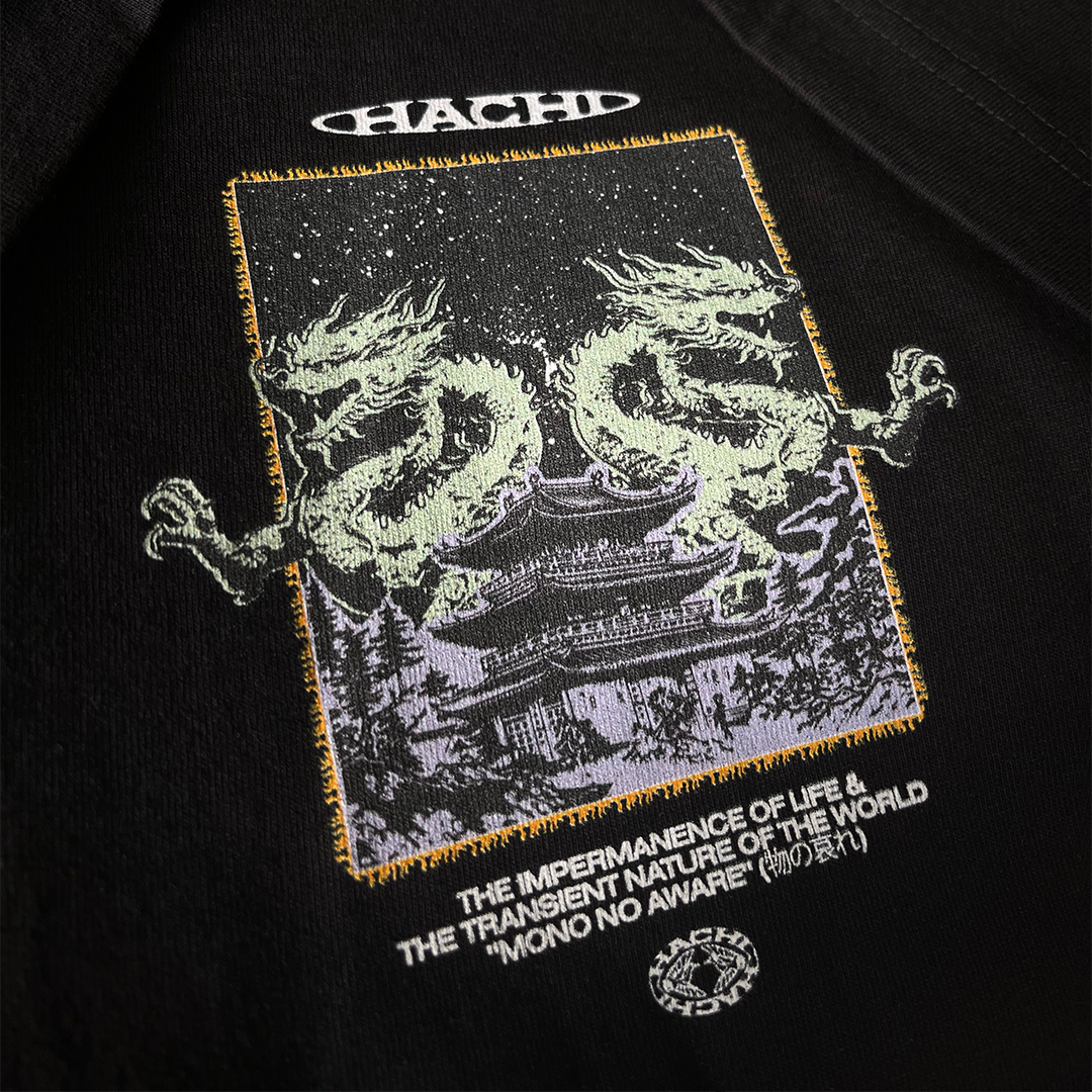 Close up of a Hachiman JPN Black oversized organic t-shirt featuring a pastel colour front print of two Japanese dragons guarding a temple beneath a starry sky