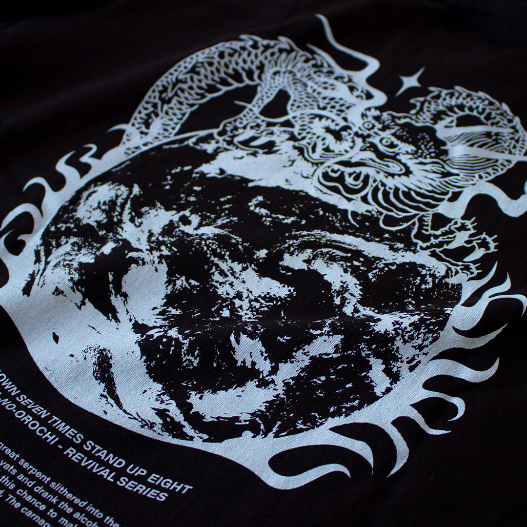Close up of a Hachiman JPN Black oversized organic t-shirt featuring a light blue back print of a Japanese dragon wrapped around earth engulfed in flame.