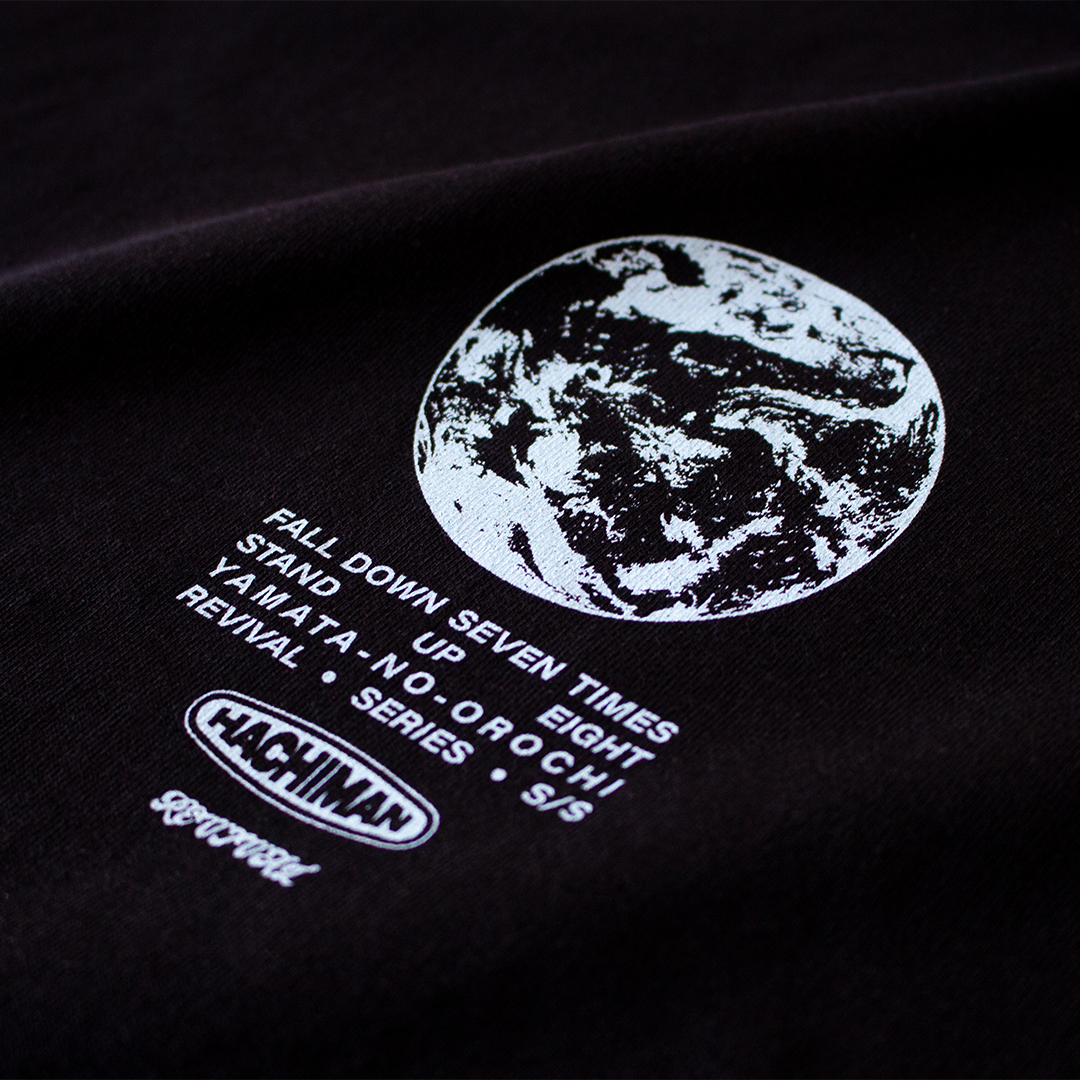 Close up of a Hachiman JPN Black oversized organic t-shirt featuring a light blue front print of Earth with text and logo's beneath.